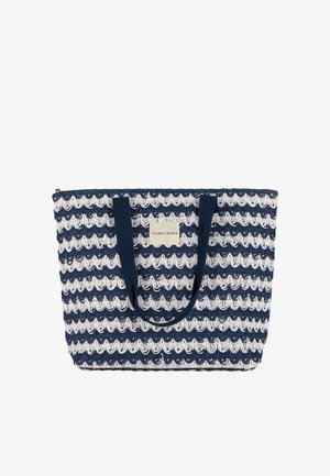 Bolso tote de ganchillo azul marino y blanco con dos asas azul marino y una etiqueta rectangular en el centro frontal que dice "Ysabel Mora".