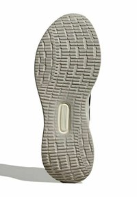 Suela de zapato con superficie texturizada de goma; color crema beige con múltiples patrones de banda de rodadura y una ranura central para flexibilidad.