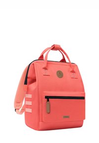 Coral-colored backpack made of durable fabric, featuring a front pocket with zipper, a logo patch, and adjustable padded straps.