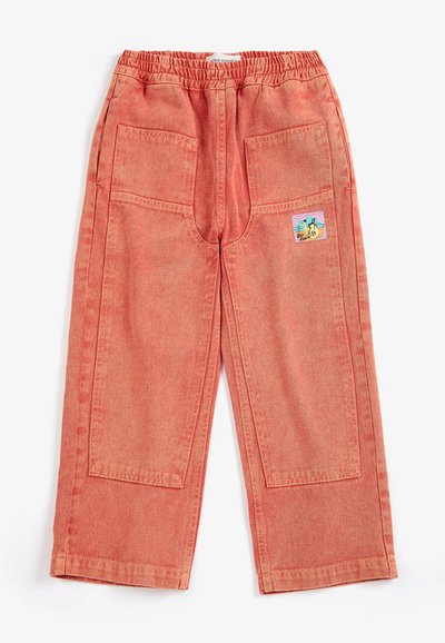 Pantalon pour enfants rose corail avec taille élastique, deux grandes poches plaquées à l'avant et un petit patch coloré sur la poche droite.