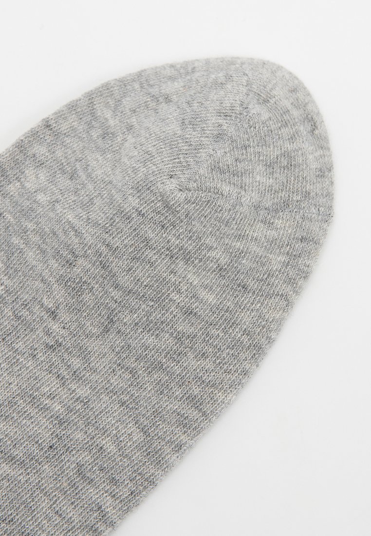 Szara skarpetka o gładkiej teksturze, z zaokrąglonym palcem i subtelnym melanżowym wzorem. Wykonana z miękkiego, elastycznego materiału.