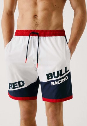 Swim shorts made of lightweight fabric, featuring a white base with navy and red accents, elastic waistband, and printed text "RED BULL RACING."