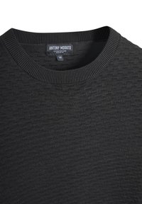 Crni pleteni pulover s teksturiranim uzorkom, okruglim izrezom i rebrastim rubovima. Etiketa nosi naziv "ANTONY MORATO" s natpisom "Cotton Soft Yarn." Standardni kroj.