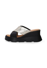 Zwarte en metallic zilveren wedge sandaal met een kruisbandontwerp, textuurkurken binnenzool en een dikke geribbelde zool.