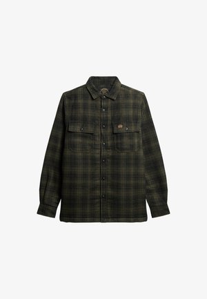 Camisa de cuadros en verde oscuro y negro, hecha de tela de franela, con dos bolsillos frontales, botones negros y una etiqueta de la marca en el pecho izquierdo.