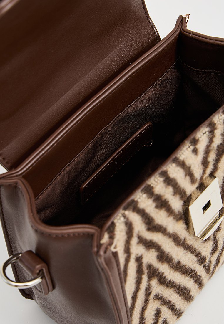 Braune Ledertasche mit einer weichen, flauschigen Zebramuster-Front. Silberne Hardware-Verschluss und ein braunes Innenfutter mit Fächern.