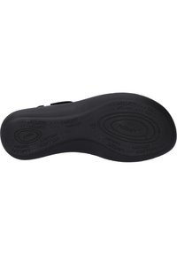 Suola di scarpa in gomma nera con superficie strutturata, caratterizzata da marchi in rilievo e motivi decorativi, forma curva per il supporto dell'arco.