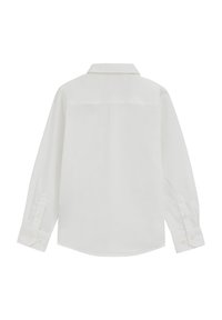 Cămașă albă cu mâneci lungi realizată dintr-un material neted, având guler clasic, manșete cu nasturi și tiv curbat la bază.