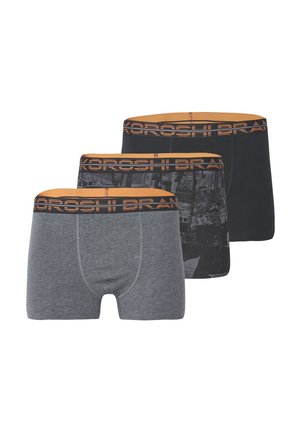 Tres pares de bóxers para hombre: uno gris, uno negro con un patrón y uno negro sólido. Todos presentan una cinturilla de marca en color naranja.