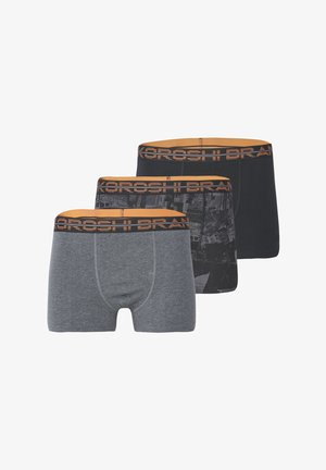 Tres pares de bóxers para hombre: uno gris, uno negro con un patrón y uno negro sólido. Todos presentan una cinturilla de marca en color naranja.