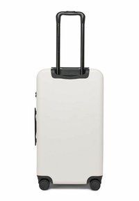 Weißer Hartschalenkoffer mit schwarzem Teleskopgriff, seitlichem Griff und vier schwarzen Rädern auf weißem Hintergrund.