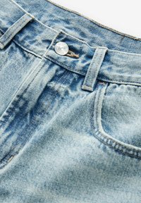 Ljusblå jeans i denim med en klassisk femfickdesign, silverfärgade knappar och synliga söm detaljer.