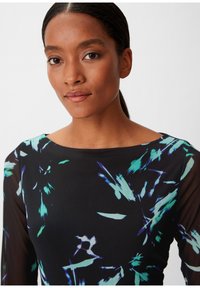 Schwarzes Kleid mit floralem Muster in Blau- und Grüntönen. Es hat einen runden Ausschnitt und lange, durchsichtige Ärmel.