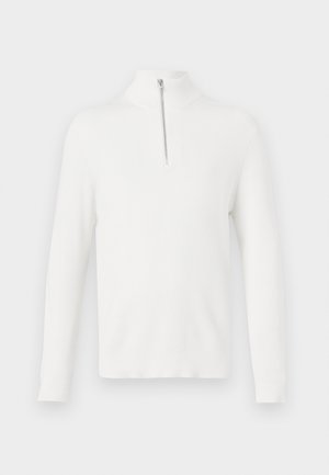 Pullover bianco a coste con maniche lunghe e collo alto. Dotato di una dettagli zip anteriore argentata. Texture morbida e forma aderente.