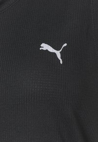 Must mustriba kangaspaita, millel on valge Puma logo. Tekstuur on sile ja peeneid jooni, rõhutades sportlikku disaini.