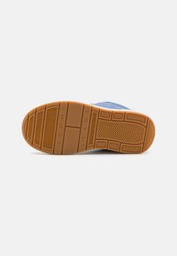 Baskets bleues avec une semelle extérieure en caoutchouc dotée d'une finition à motif pour une meilleure adhérence, le nom de la marque "TOMMY JEANS" en relief, et un dessus en tissu rembourré.