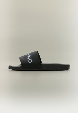 Black slide sandal with a wide strap featuring "VALENTINO" in white text, rubber sole with textured underside and sleek design.
