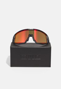 Ochelari de soare sport negri cu lentile roșii reflectorizante, design aerodinamic și bentiță lată; prezențați pe o cutie neagră cu logo embossat.