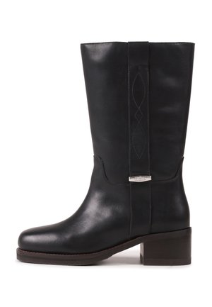 Melns vidēja garuma ādas zābaks ar zemu bloka papēdi, apaļu purngalu, dekoratīvām šuvēm uz kājas daļas un metāla detaļu uz sānu siksnas.