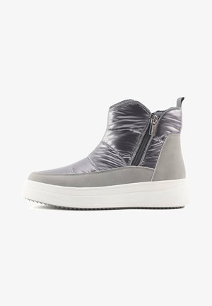 Pelēki potīšu zābaki ar spīdīgu, mīkstu augšdaļu, kontrastējošām pelēkām zamša akcentiem un baltu gumijas zoli. Iespējama sānu rāvējslēdzis, kas nodrošina vieglu uzvilkšanu.