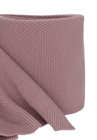 Coperta lavorata a maglia in morbido malva, con motivi testurizzati e finitura liscia. I bordi sono leggermente arrotolati per un aspetto informale.