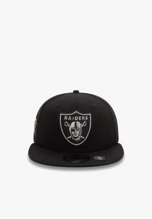 Casquette de baseball noire avec un visière plate. Présente un logo brodé des Raiders en gris à l'avant. Fabriquée en tissu avec une texture lisse.