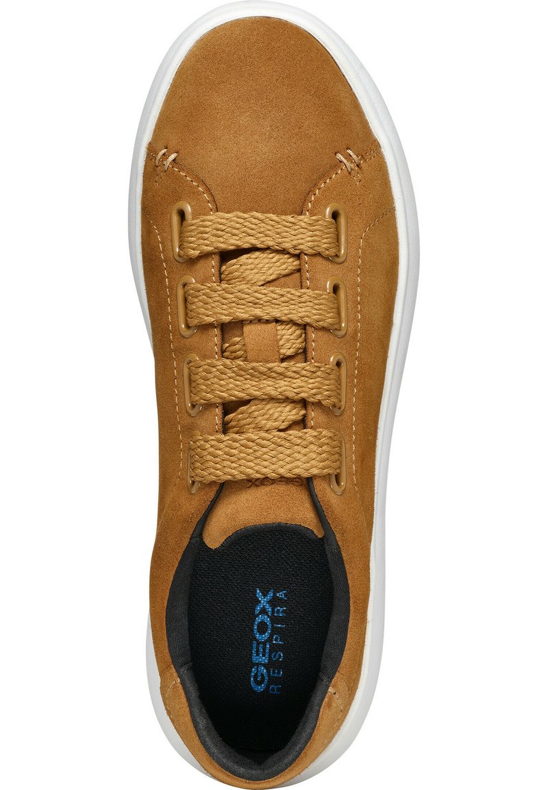 Sneaker in suede tan con punta rotonda, chiusura con lacci e suola in gomma bianca a contrasto. Presenta un interno nero e un logo visibile.