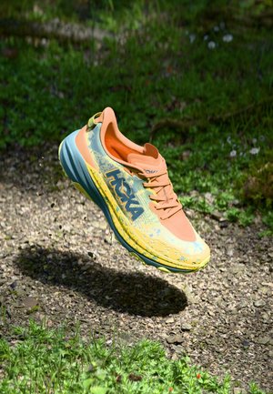 Lightweight running shoe with a multicolored upper, featuring orange, yellow, and blue tones. Textured pattern on the surface and cushioning sole.
