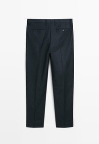 Ciemnoniebieskie spodnie o dopasowanym kroju, z dwoma tylnymi kieszeniami i gładką fakturą, pokazane od tyłu na jednolitym białym tle.