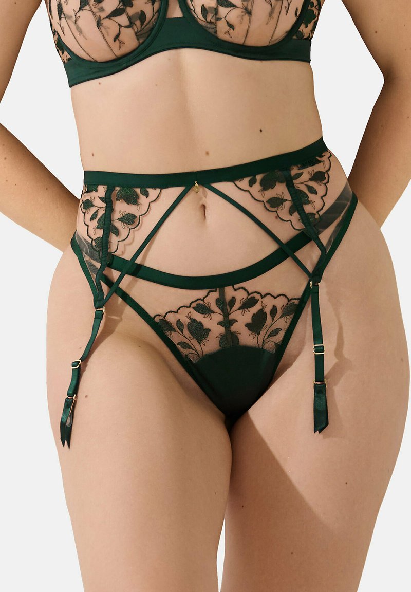 Ensemble de lingerie vert foncé avec des détails en dentelle florale. Comprend des panneaux en mesh transparent, un motif complexe, et des bretelles ajustables avec des accents dorés.