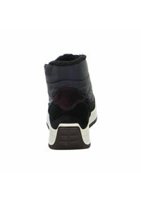 Botín tipo puffer negro con acentos de ante, parte superior texturizada, forro suave y suela blanca acolchada con patrón de relieve para mejor agarre.