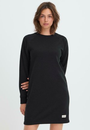 Zwart sweatshirtjurk met lange mouwen, gemaakt van zacht materiaal, met een ronde halslijn en een klein merkje aan de zoom.