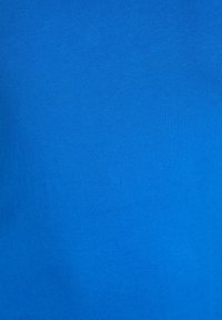 Svijetloplavi pamučni materijal s glatkom teksturom. Materijal izgleda lagano i nije ukrašen, prikazujući jednostavnost u dizajnu.