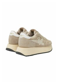Beige suede sneakers with white accents, featuring a chunky cream platform sole and a textured interior lining. Branding visible on the heel.