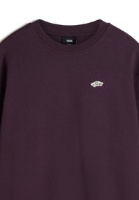 Fioletowa bluza z miękkiego materiału, z okrągłym dekoltem i małym białym logo "Vans Off The Wall" na piersi.