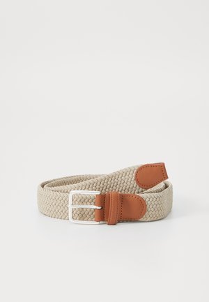 Ceinture en tissu tissé beige avec bouts en cuir fauve et boucle rectangulaire argentée, enroulée sur fond blanc.