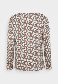 Blusa a maniche lunghe in tessuto crema con un audace motivo geometrico in nero, rosso e beige, dal taglio rilassato e con spalle leggermente arricciate.