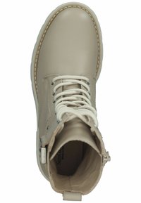 Botín de cuero beige con cordones, puntera redonda, cremallera interior y costuras en contraste. Textura suave y diseño minimalista.