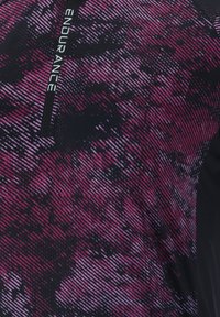 Letvægts atletisk top i sort og gradient pink med en kvart-zip krave, tekstureret mønster og 'ENDURANCE' logo detalje.