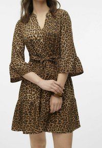 Robe en imprimé léopard en tissu doux, dotée d'un décolleté en V, de manches évasées et d'une taille à nouer. La jupe présente un design à niveaux.