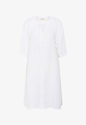 Weißes Leinenkleid mit rundem Ausschnitt, Kordelzugverschluss und bestickten Details entlang der Vorderseite. Dreiviertelärmel mit elastischen Bündchen.