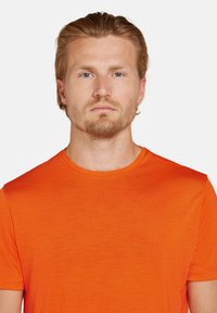 Orange t-shirt lavet af blødt, letvægtsstof. Har en klassisk rund halsudskæring og korte ærmer med en glat tekstur.