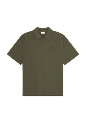 Polo de manga corta en color verde oliva con tres botones y un pequeño parche cuadrado negro con el número romano II en el pecho.