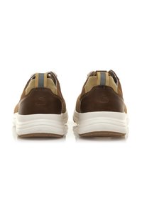 Sneaker in pelle marrone e mesh con suola bianca, dotate di una linguetta sul retro e una striscia grigia di accentuazione sul tallone. Dettagli in materiale testurizzato visibili.