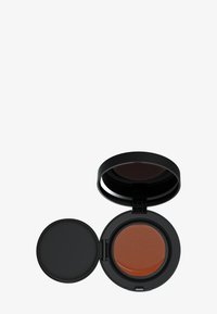 Kussenfoundation in een zwarte ronde compact. Open de deksel en je ziet een bruine, textuurachtige productzone en een aparte zwarte binnenklep.