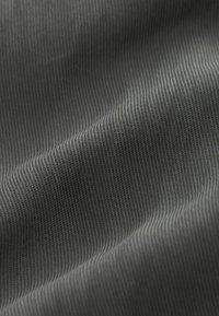 Tessuto grigio strutturato con fine rigatura verticale, che crea una texture liscia e una leggera lucentezza. Materiale morbido e flessibile.