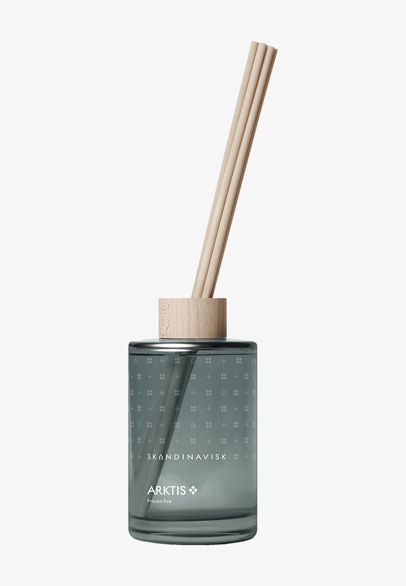 Bouteille diffuseuse en verre avec capuchon en bois et trois tiges diffuseuses, étiquetée "Skandinavisk ARKTIS Frozen fire," sur fond blanc.