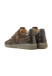 Pair of brown suede and patent leather sneakers with tan interior lining and translucent rubber soles, shown from a rear three-quarter view.