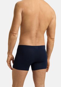 Boxer briefs azul marino hechos de una tela suave, con un ajuste ceñido y un diseño sin costuras, que incluyen una cinturilla suave y sin logos visibles.