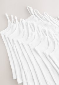 Des caracos en coton blanc disposés en ligne décalée, avec des fines bretelles et une bordure en dentelle au niveau du col. Texture douce dans l'ensemble.